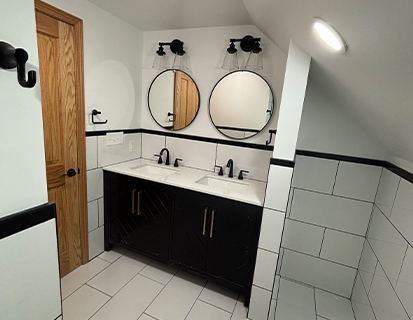 Modern bathroom with black vanity and round mirrors in Columbus, OH remodel